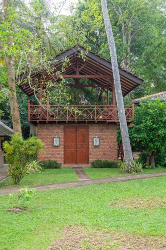 a house with a red door in a yard at Ging Oya Lodge in Waikkal