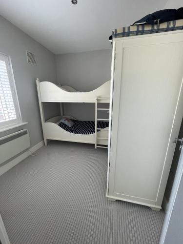 a room with a white bunk bed next to a door at 21 Victoria, Kilkee in Kilkee