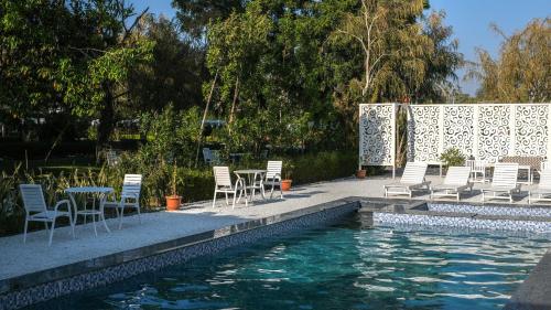 a pool with chairs and a table and a pool of water at Bodhi Retreat in Pushkar