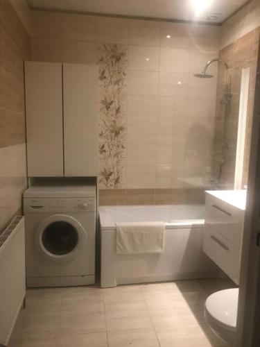 a bathroom with a washing machine and a washer at Pokoje gościnne na Miłej in Kochlice