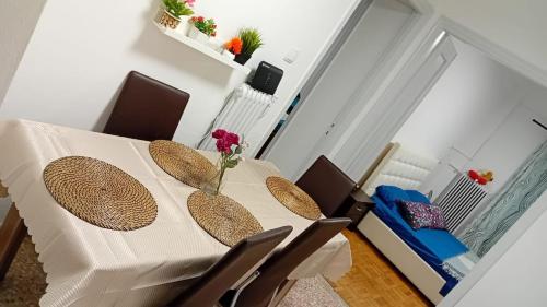 een witte tafel met stoelen en een vaas met bloemen erop bij Appartement tout confort in Athene