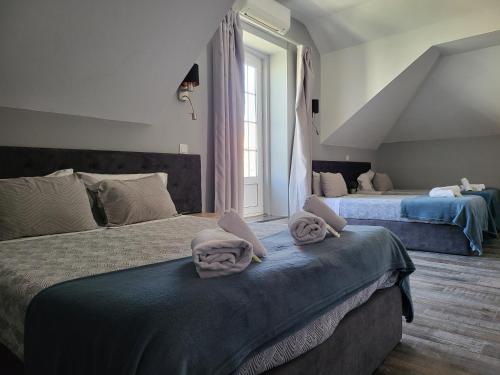 a bedroom with two beds with towels on them at Leao de Ouro in Matosinhos