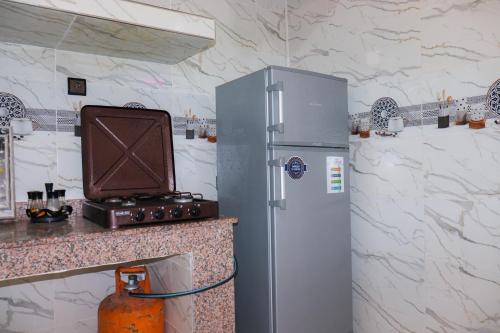 APPARTEMENT DE LUXE A LAAYOUNe في العيون: ثلاجة من الحديد المقاوم للصدأ في مطبخ مع منضدة