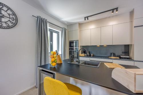 a kitchen with a black counter and yellow chairs at Villa Alves with Private Pool in Tar