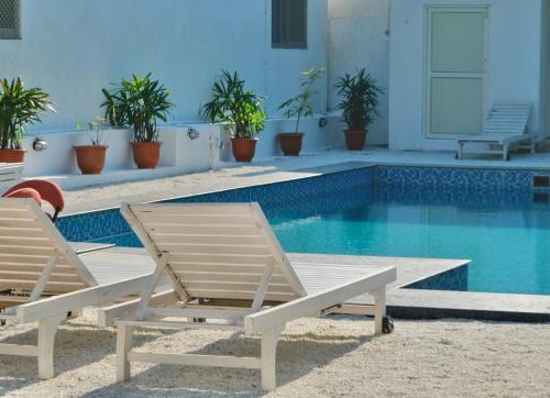 two chairs sitting next to a swimming pool at Bodhi Retreat in Pushkar