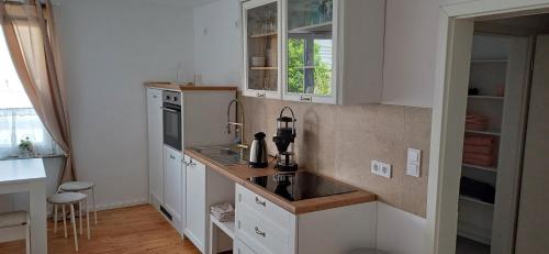 a white kitchen with a sink and a stove at Schnick Schnack in Kröv