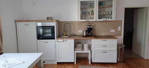 a kitchen with white cabinets and a white refrigerator at Schnick Schnack in Kröv