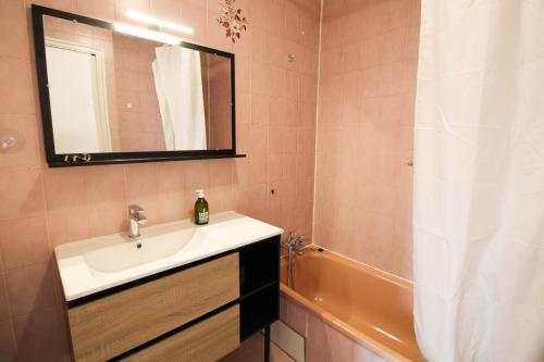 une salle de bain avec un lavabo, un miroir et une baignoire dans l'établissement Monlogis 6 Grand Studio lumineux- Fibre, à Angoulême