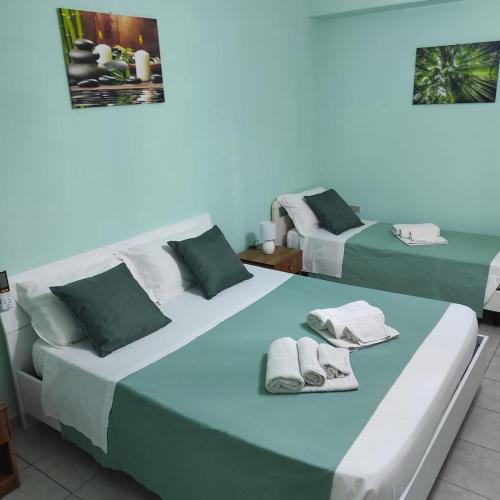 two beds in a room with towels on them at B&B Leonida in Tropea