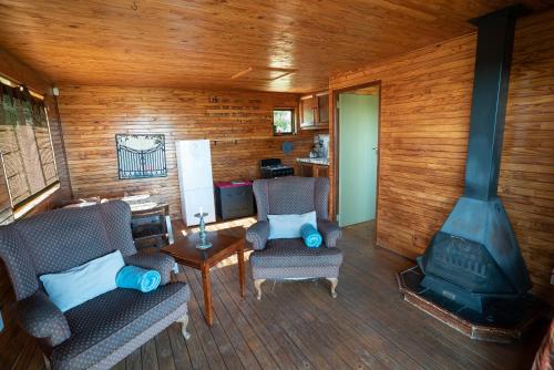 a living room with two chairs and a fireplace at Kokopelli farm in Magaliesburg