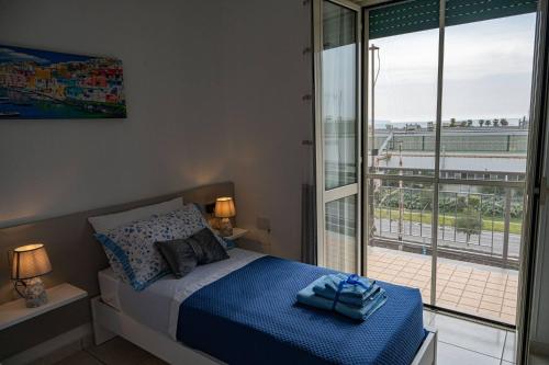 a bedroom with a bed and a large window at Mare Fuori casa vacanze in Castellammare di Stabia