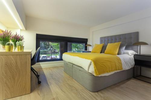 um quarto com uma cama com uma colcha amarela em Apartamento Retiro V en Madrid em Madri