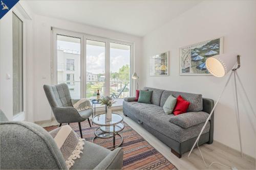 a living room with a couch and two chairs at Haffblick 1 in Zirchow