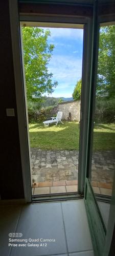an open window with a view of a bench outside at MALPAS125 maison 6 chambres 10personnes in Accons