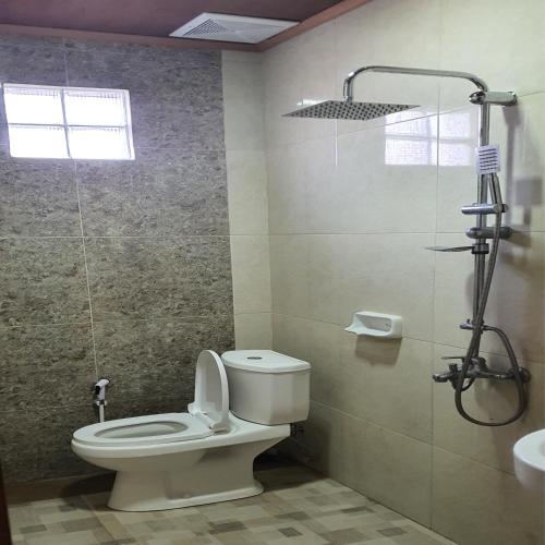 a bathroom with a toilet and a shower at EDUTAMA Homestay Syariah in Kediri