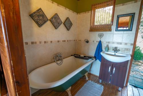 a bathroom with a bath tub and a sink at Kokopelli farm in Magaliesburg