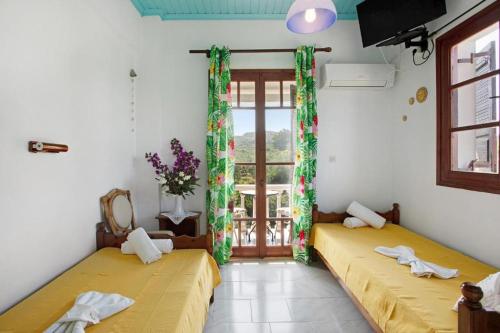 two beds in a room with a window at Areti Orfeas Studios in Vasilikos