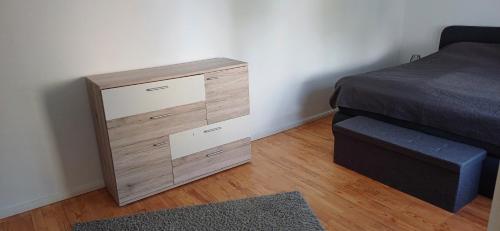 a wooden dresser in a bedroom next to a bed at Schnick Schnack in Kröv