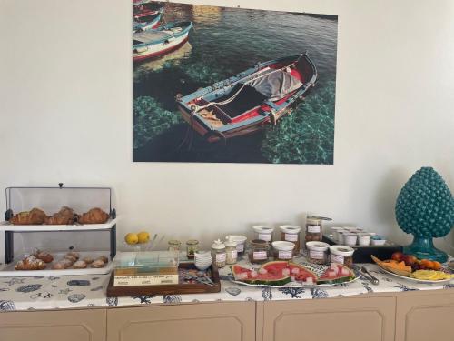 a table with food and a boat on the water at SUITEBEACH b&b and resort in Marsala