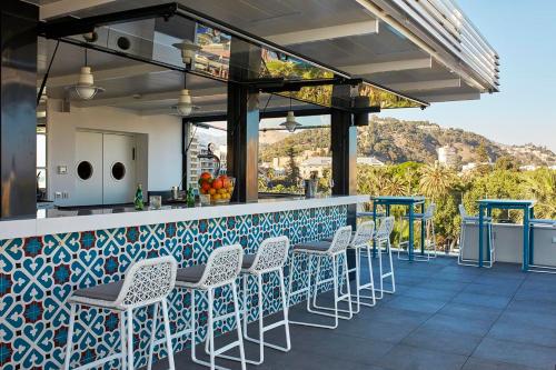 a bar with white chairs and a blue and white counter at Room Mate Collection Valeria, Málaga in Málaga