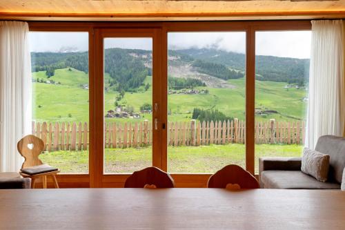 a living room with a table and a large window at Paracia App Cir in Badia
