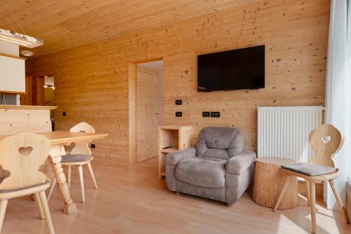 a living room with a chair and a tv on a wall at Paracia App Cir in Badia
