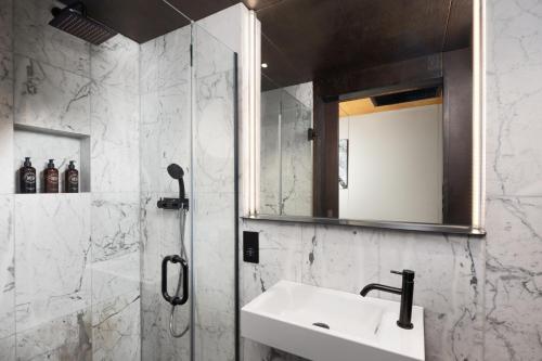 a bathroom with a sink and a mirror at Stow Away Waterloo in London