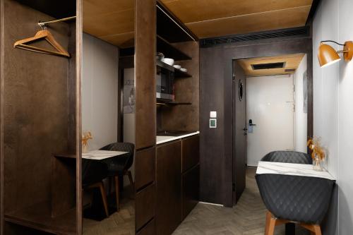 a room with two chairs and a table and a hallway at Stow Away Waterloo in London