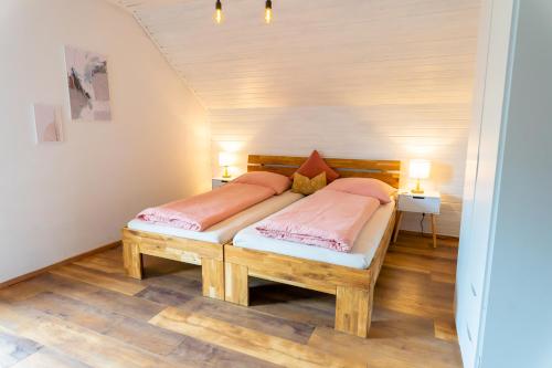 a bedroom with a wooden bed with two pink pillows at Apartment Bergglück im Lungau in Sankt Michael im Lungau