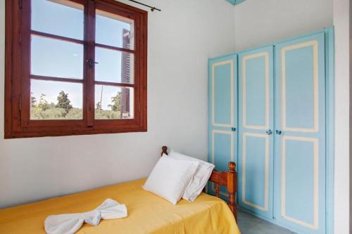 a bedroom with a bed with a window and a dresser at Areti Orfeas Studios in Vasilikos