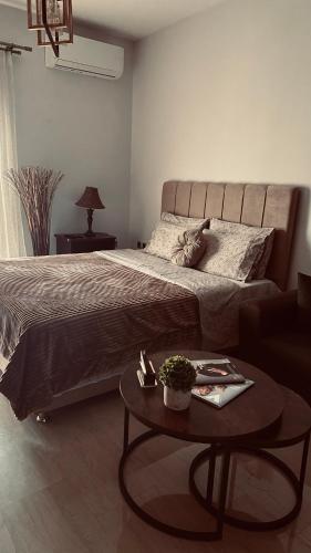 - une chambre avec un grand lit et une table basse dans l'établissement Nina Apartment, à Dráma