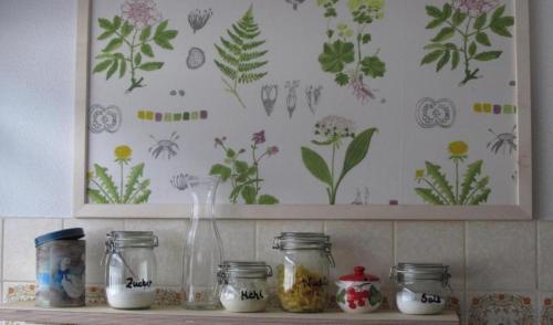 a shelf with jars and flowers on a wall at Wohnung Aal Obstbeem in Rommersheim mit Garten und Grill in Rommersheim