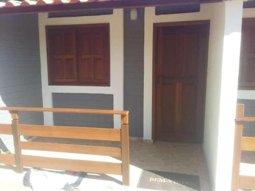 a house with two doors and a bench in front at Pousada Kart Clube in São João del Rei
