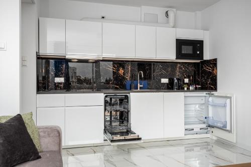 a white kitchen with white cabinets and appliances at Warsaw Modern Stay in Warsaw