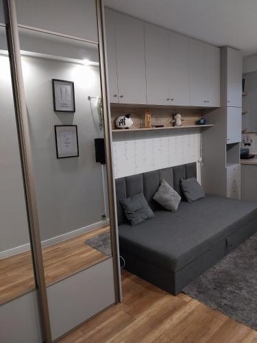 a bed in a small room with a mirror at Apartament na Sadowej in Sanok