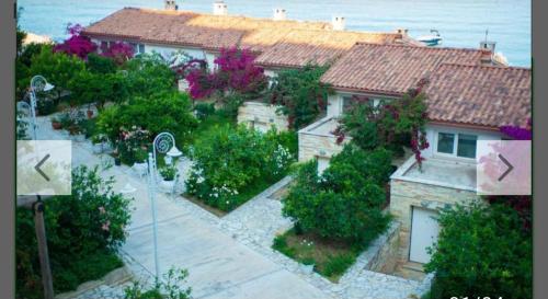 a house with a garden in front of it at Bougainvill Sunset Villa in Sarandë