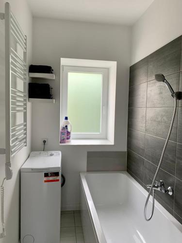 a bathroom with a tub and a sink and a window at Quattro Casa in Sopron