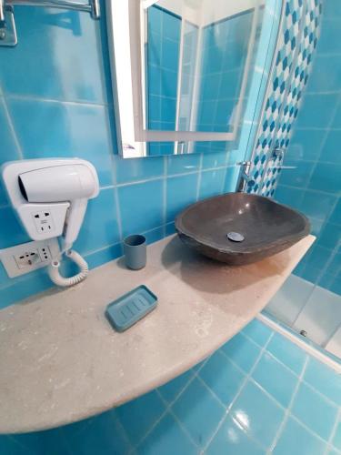 a blue tiled bathroom with a toilet on a counter at VisitPonza - Le Naiadi in Ponza