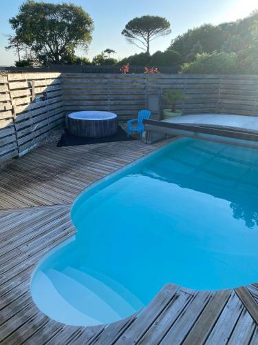 - une piscine bleue sur une terrasse en bois dans l'établissement LA CABANE DE L'ESTUAIRE chambres d'hôte, à Meschers-sur-Gironde