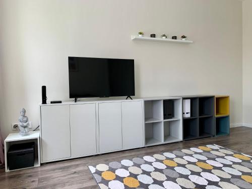 a white entertainment center with a television on top of it at Quattro Casa in Sopron