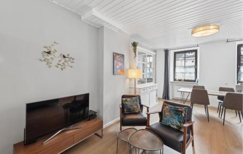 a living room with a flat screen tv and chairs at 2 Bedroom Awesome Apartment In Malberg in Malberg