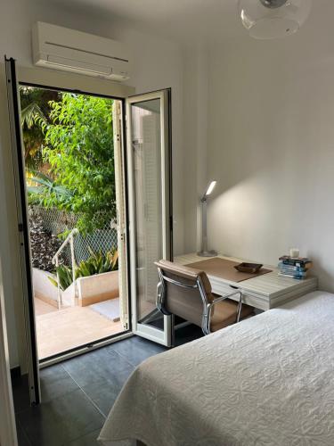 - une chambre avec un lit, un bureau et une porte coulissante en verre dans l'établissement Perfectly located holiday place, à Beaulieu-sur-Mer