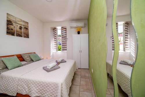 1 dormitorio con 2 camas y pared verde en SkyGarden House, en Mali Lošinj
