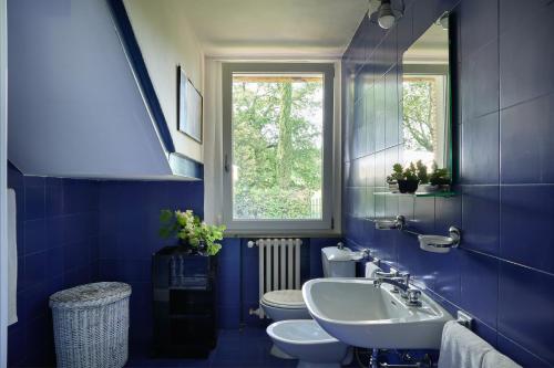 a blue bathroom with a sink and a toilet at Casa Mancini Monticiano - Holiday Villa in Monticiano