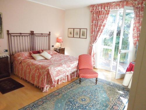 a bedroom with a bed and a chair and a window at Villa Olivia in Bergamo