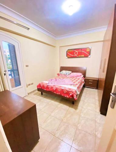 a bedroom with a bed with a red comforter at قرية نيس in Dawwār Muşādif Yūnus