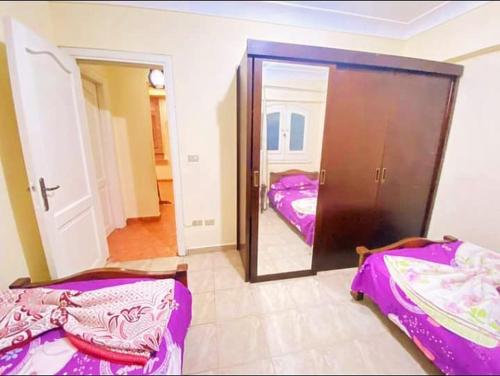 a bedroom with two beds and a large mirror at قرية نيس in Dawwār Muşādif Yūnus