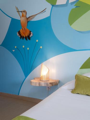 a bedroom with a blue wall with a bird on the ceiling at West Side Guesthouse in Peniche
