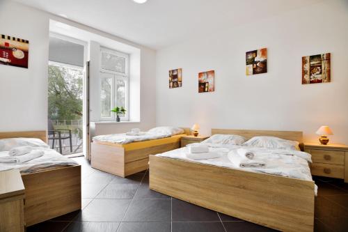 two beds in a room with white walls at Apartmány Děčín in Děčín