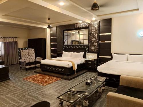pokój hotelowy z 2 łóżkami i kanapą w obiekcie MZ Hotel and Restaurant Sukkur w Kalar Goth